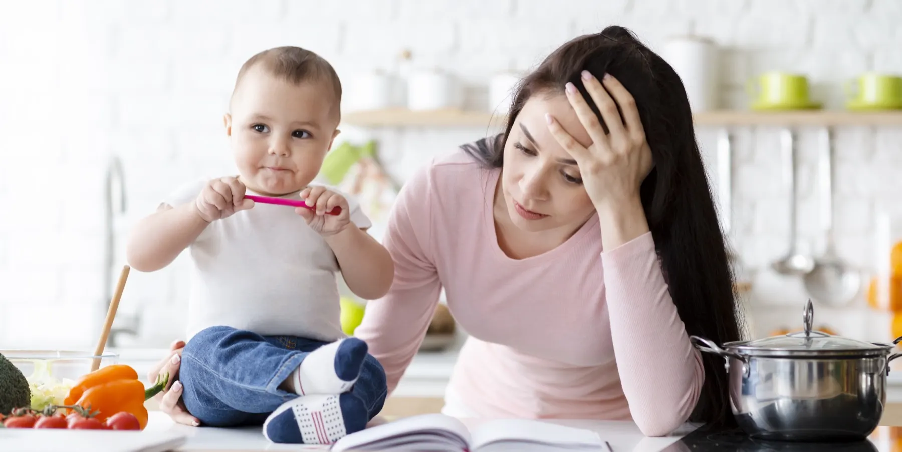 Une maman fatiguée avec son bébé dans la cuisine