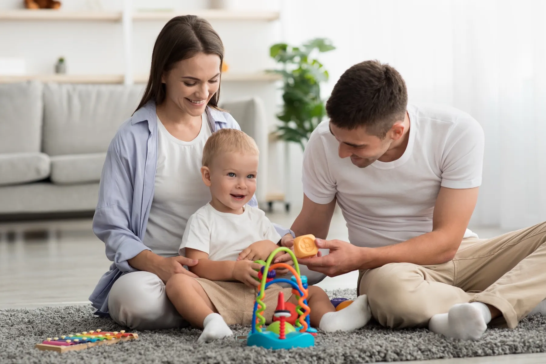 Des parents jouent avec leur tout-petit dans le salon